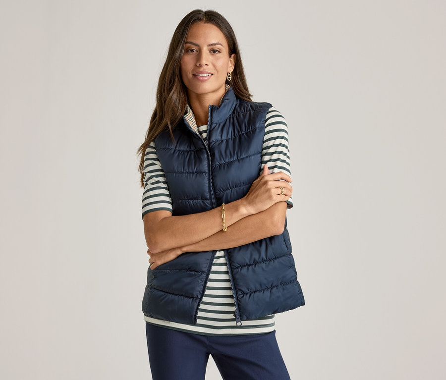 Kolları çapraz kadın, yeşil çizgili Yarım Kollu Tişört üzerine lacivert yelek giyiyor.