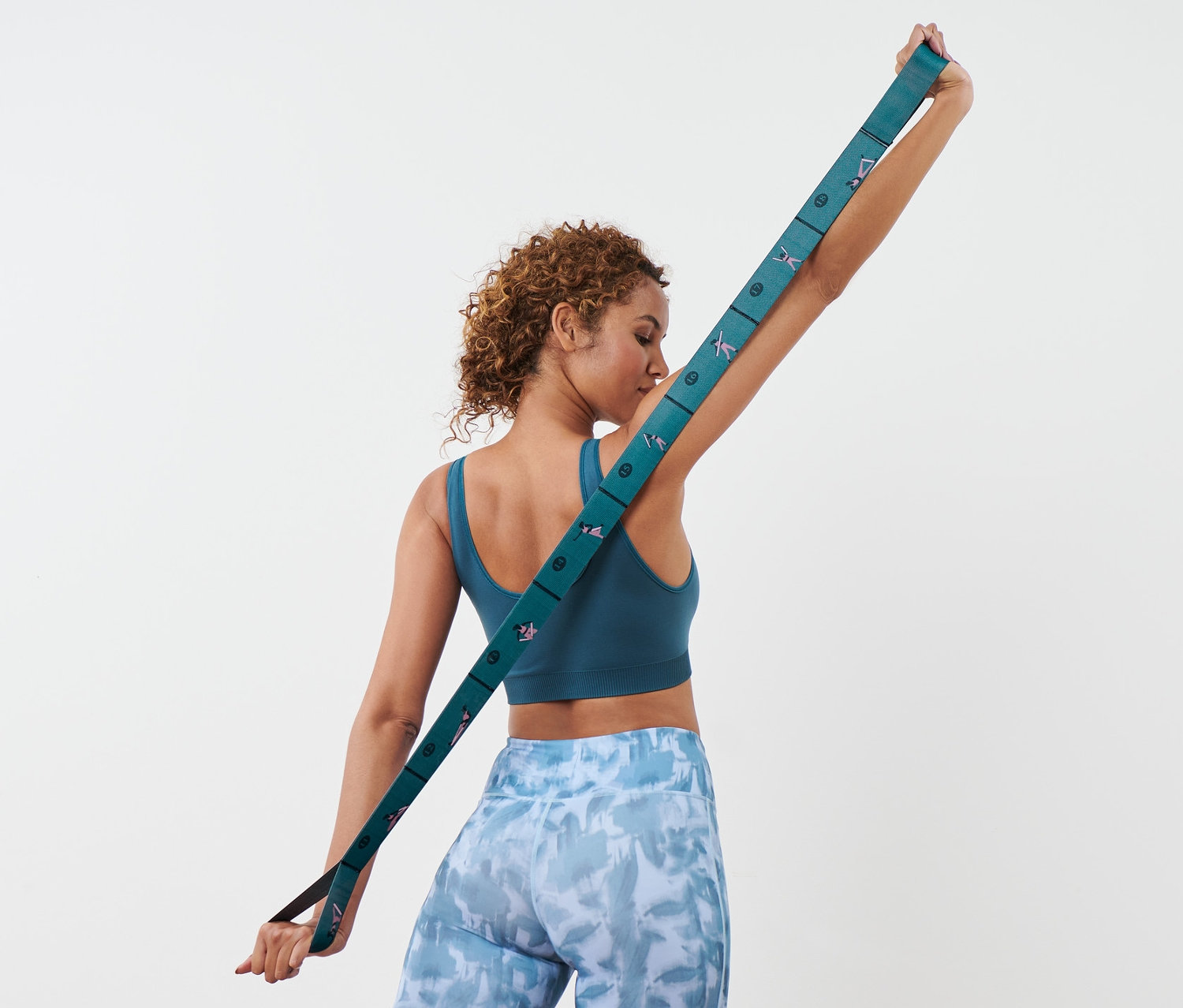 Kadın sırtının arkasında elastik direnç bandını geriyor.