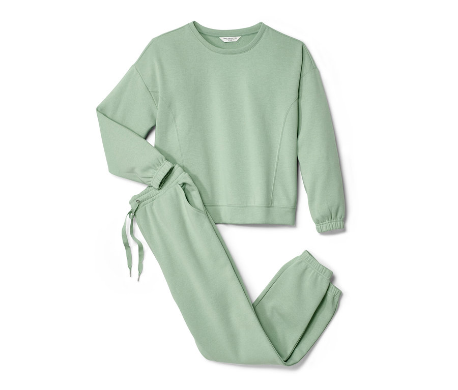 Yeşil ev eşofman takımı, sweatshirt ve eşofman altı beyaz bir zeminde duruyor.