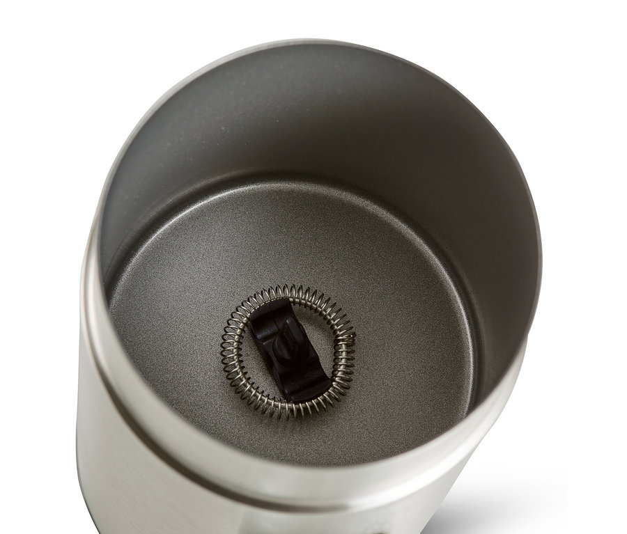 İçinde çırpma teli bulunan paslanmaz çelikten elektrikli süt köpürtücünün yukarıdan görünümü.