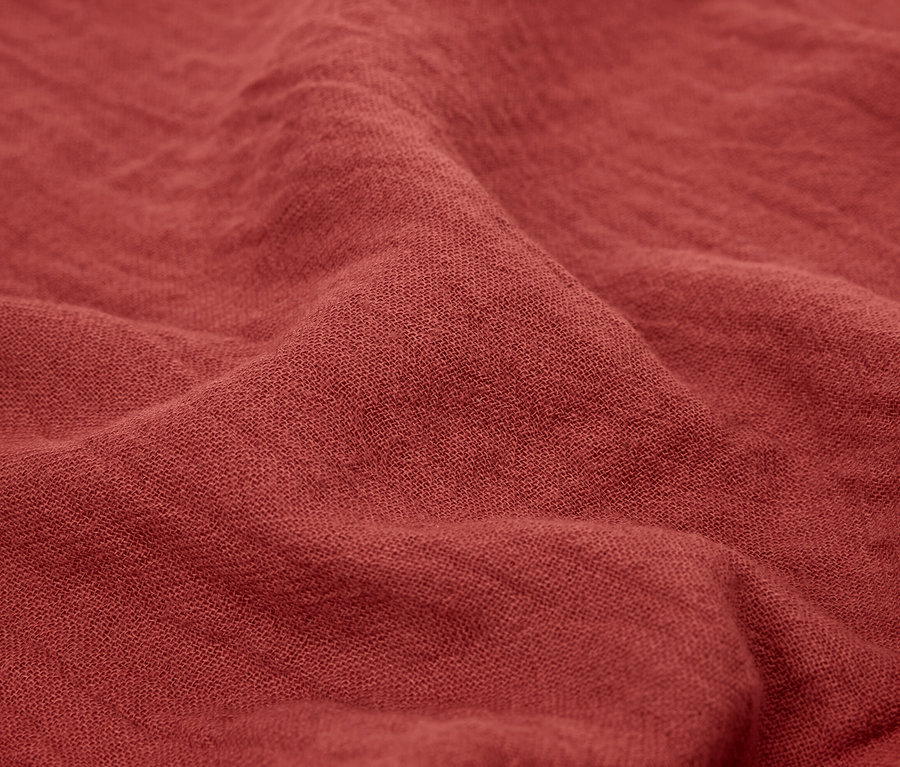 Yakın çekimde iki adet tuğla rengi müslin havlu.