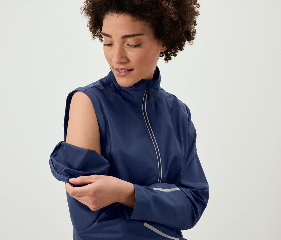 Kadın, 2'si 1 Arada Bisiklet Montu'nun kollarını çıkarıyor.