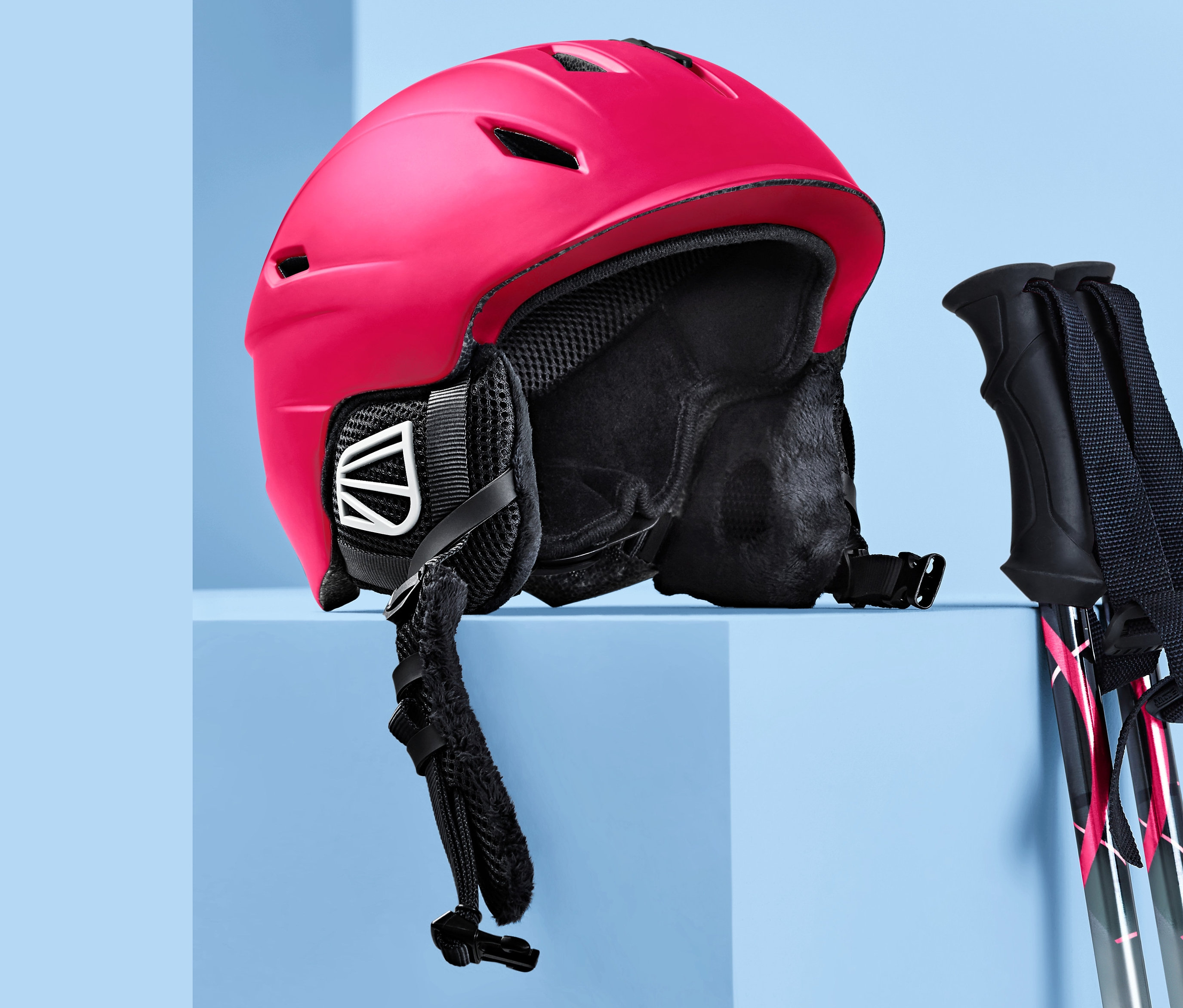 Mavi bir arka plan üzerinde kırmızı bir Kayak ve Snowboard Kaskı ve kayak direkleri.