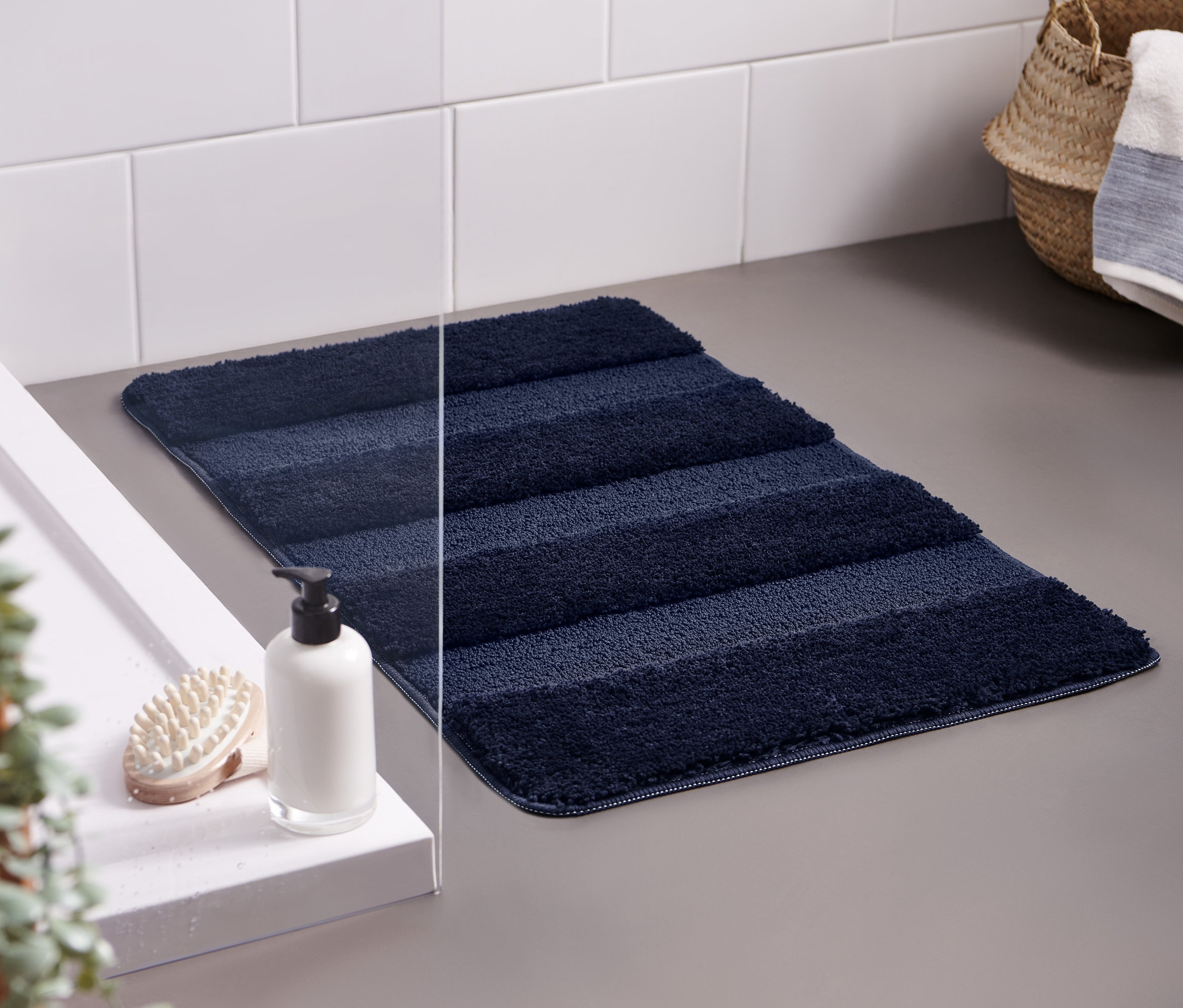 Lacivert Wellness Banyo Paspası, yakl. 50 x 80 cm, gri bir zeminde lavabonun yanında duruyor.