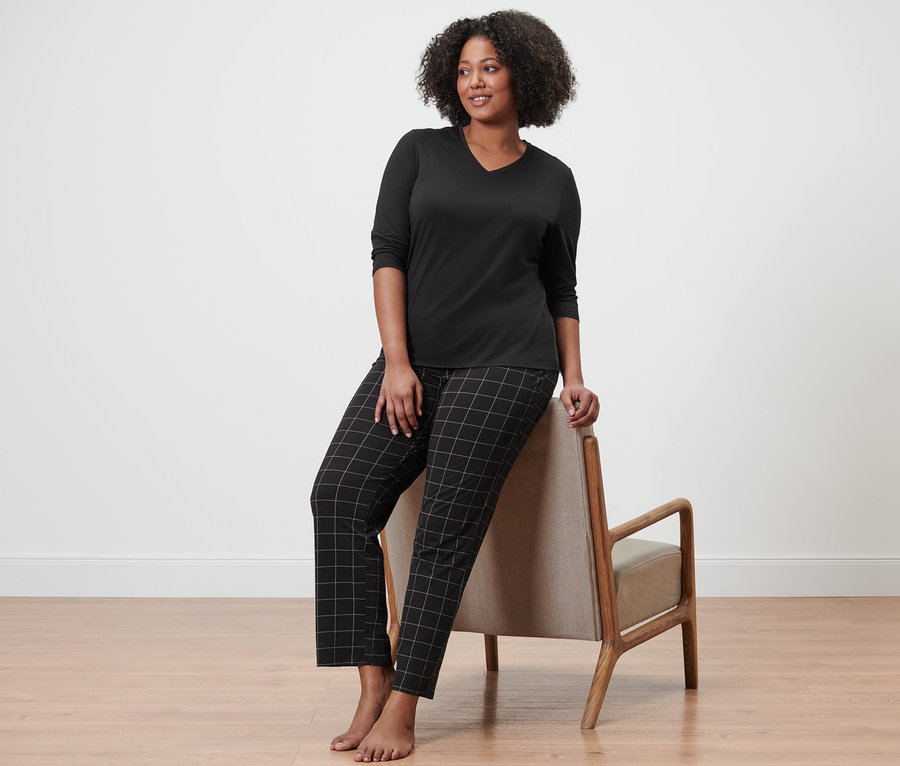 Kadın sandalyeye yaslanmış, pijama takımı giyiyor.