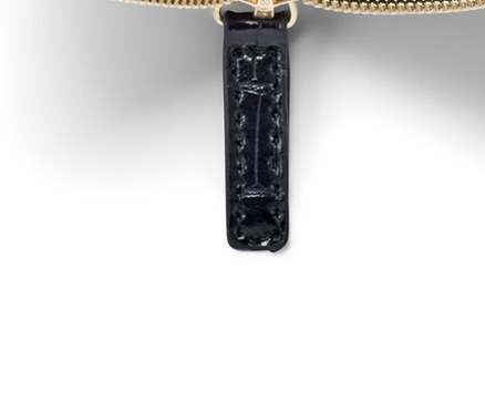 Açık, altın fermuarlı siyah cüzdan.