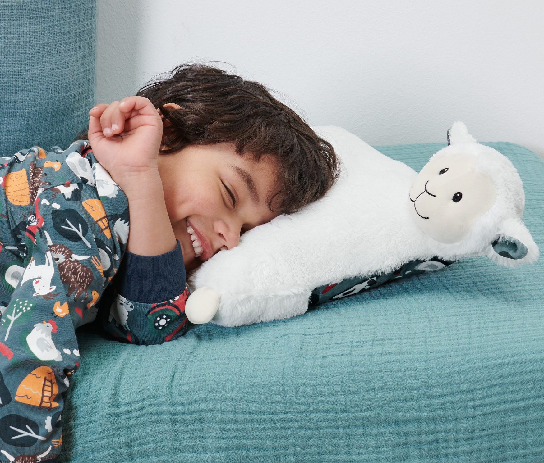 Erkek çocuk Pijama Cepli Pelüş Yastık »Koyun« üzerinde uyuyor.