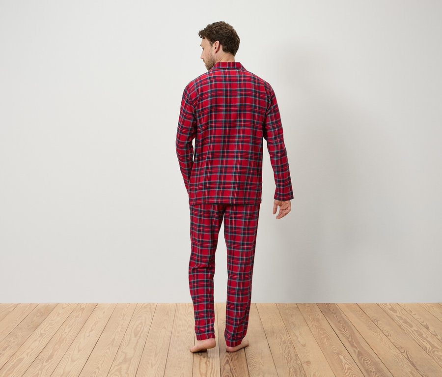 Arkası dönük bir adam kırmızı ekose pijama giyiyor.