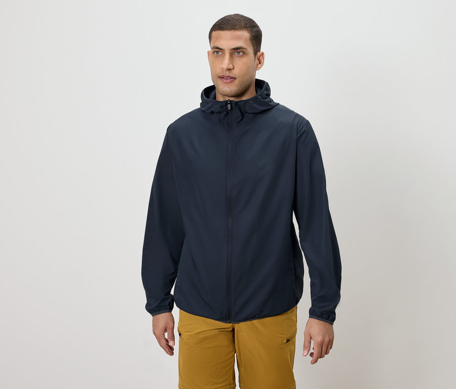 Adam lacivert kapüşonlu ceket ve altın rengi şort giyiyor.