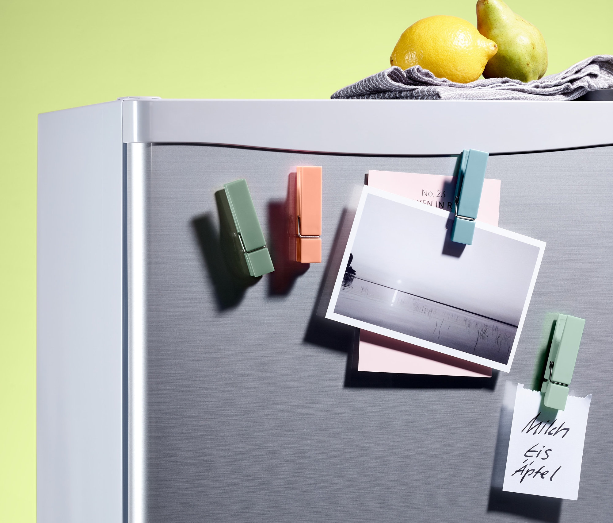 Dört adet buzdolabı magneti, bir fotoğrafı ve notları buzdolabına tutturuyor.