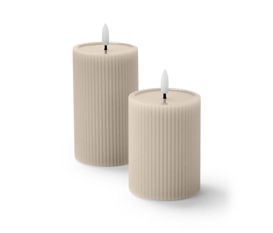 İki adet bej renkli, gerçek mum yüzeyli, oluklu LED mum yan yana duruyor.