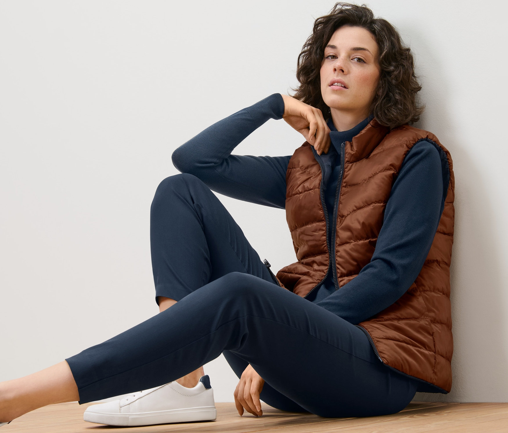 Kadın yerde oturuyor ve Çift Taraflı Yelek giyiyor.