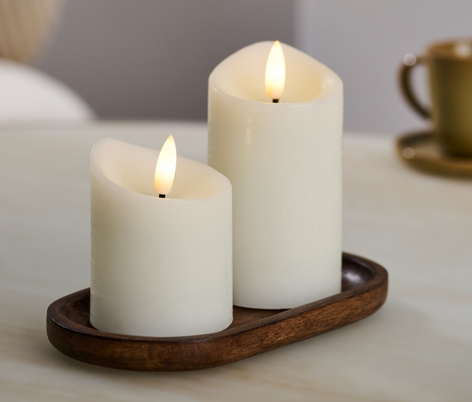 Kahverengi bir tepside iki adet krem rengi LED'li gerçek mum.