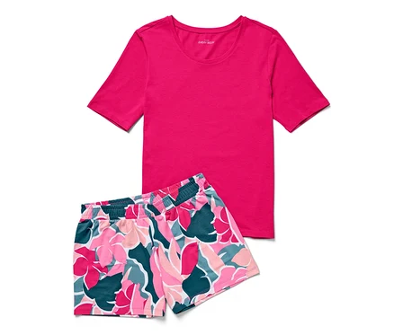 Pembe tişört ve çiçek desenli şorttan oluşan şortlu pijama takımı.