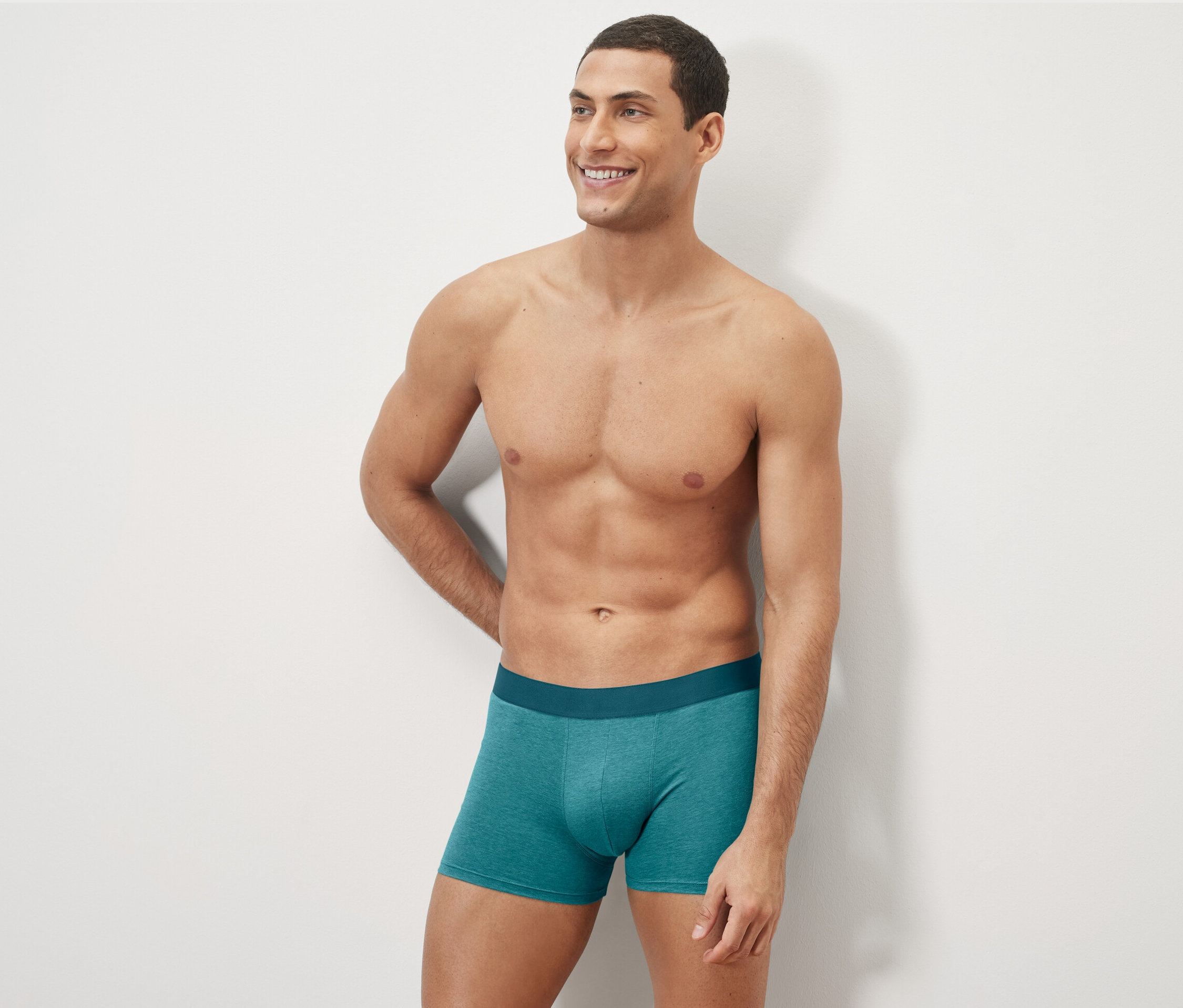 Yeşil renkli 4 Adet Slip Boxer, Tamamı Baskılı ürünü giyen bir adam poz veriyor.