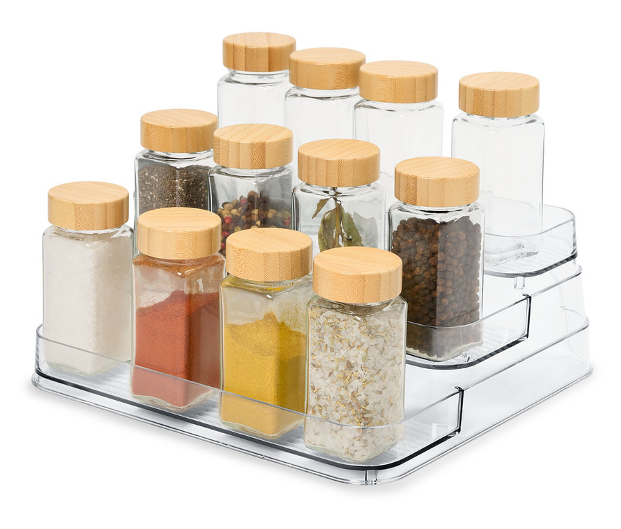 Şeffaf üç katlı bir düzenleyicide ahşap kapaklı 12 adet cam baharat kavanozu bulunmaktadır.