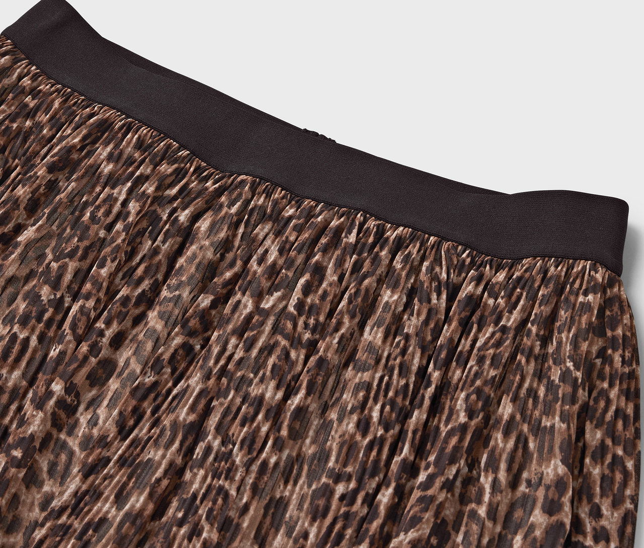 Siyah kemerli, hayvan desenli kahverengi bir eteğin detayı.