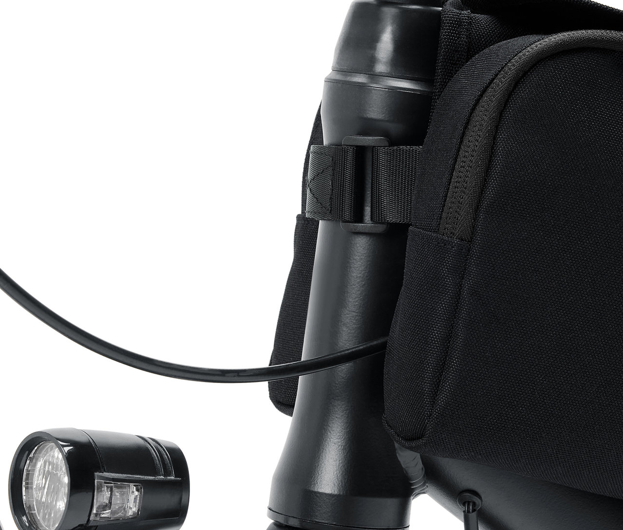 Bisiklet gidonunun, lambanın ve siyah çantanın yakın çekimi.