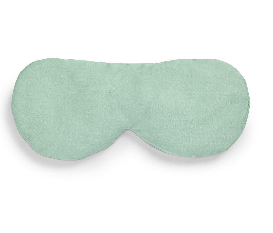 Açık yeşil bir uyku maskesi beyaz bir arka plan üzerinde duruyor.
