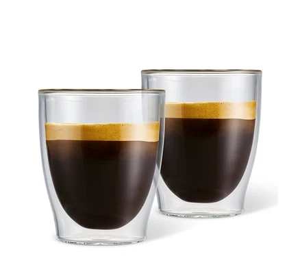 İki adet çift cidarlı Caffè Crema bardağı kahveyle dolu.