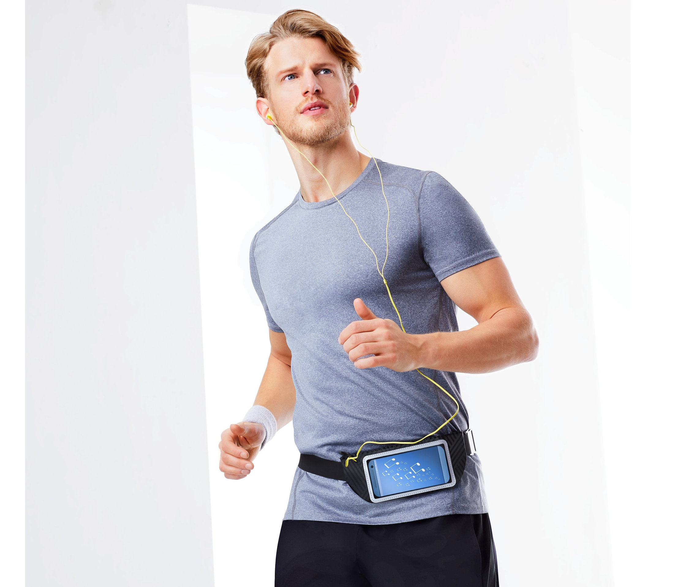 Adam akıllı telefonlar için siyah bir spor kemeri ile koşuyor.