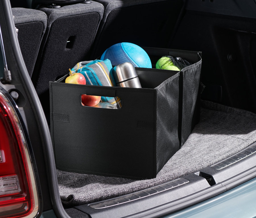 Bir arabanın bagajında, çeşitli eşyaların saklandığı katlanabilir bir bagaj kutusu bulunmaktadır.