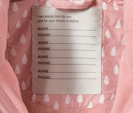 Pembe damlalı küçük çocuk softshell tulumunun iç kısmı ve isim etiketi.