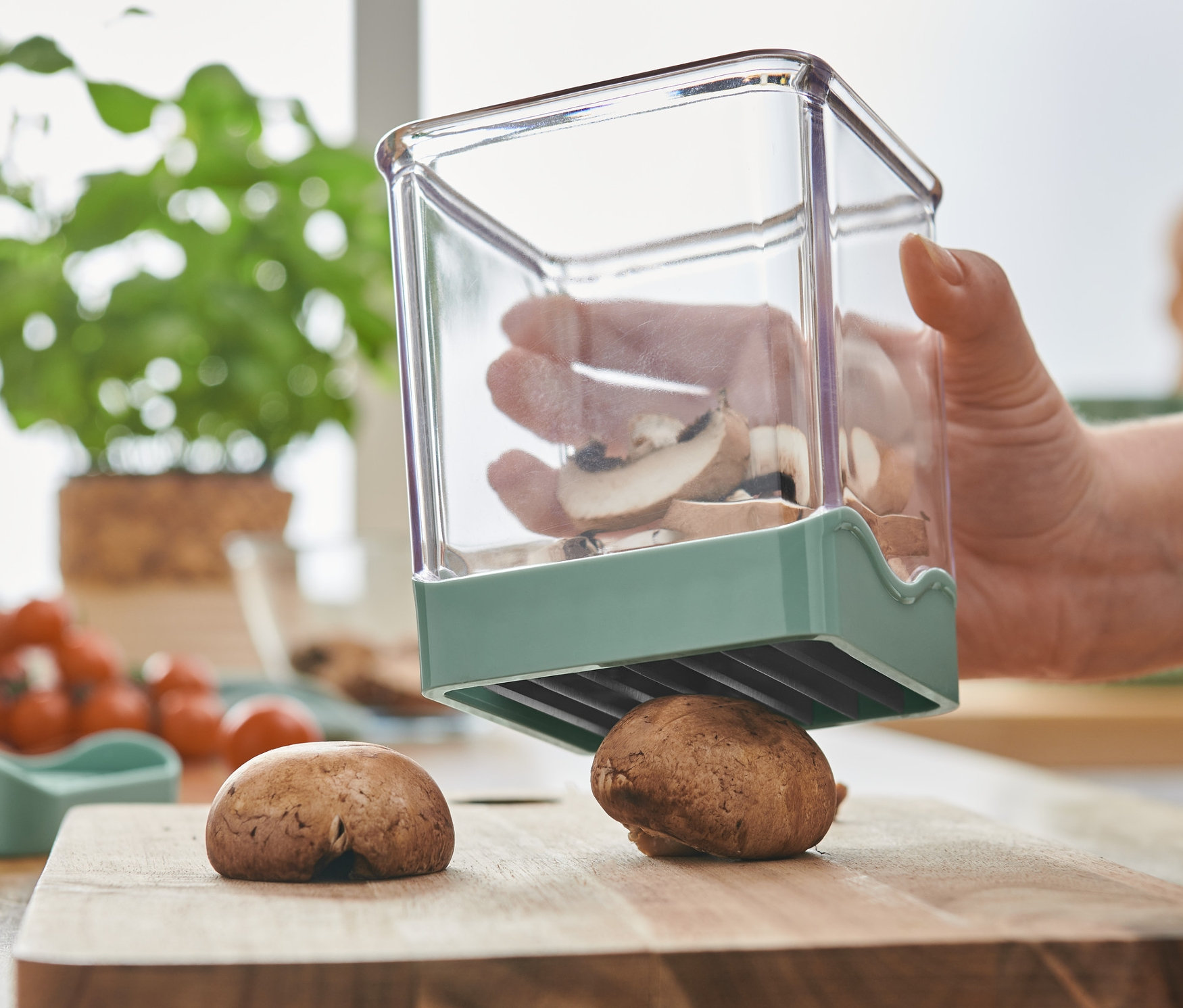 Kadın, bir meyve ve sebze dilimleyici ile mantar dilimliyor.