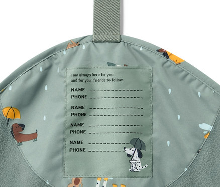 Köpek baskılı ve isim etiketi olan bir çocuk termal yağmur pantolonunun detayı.