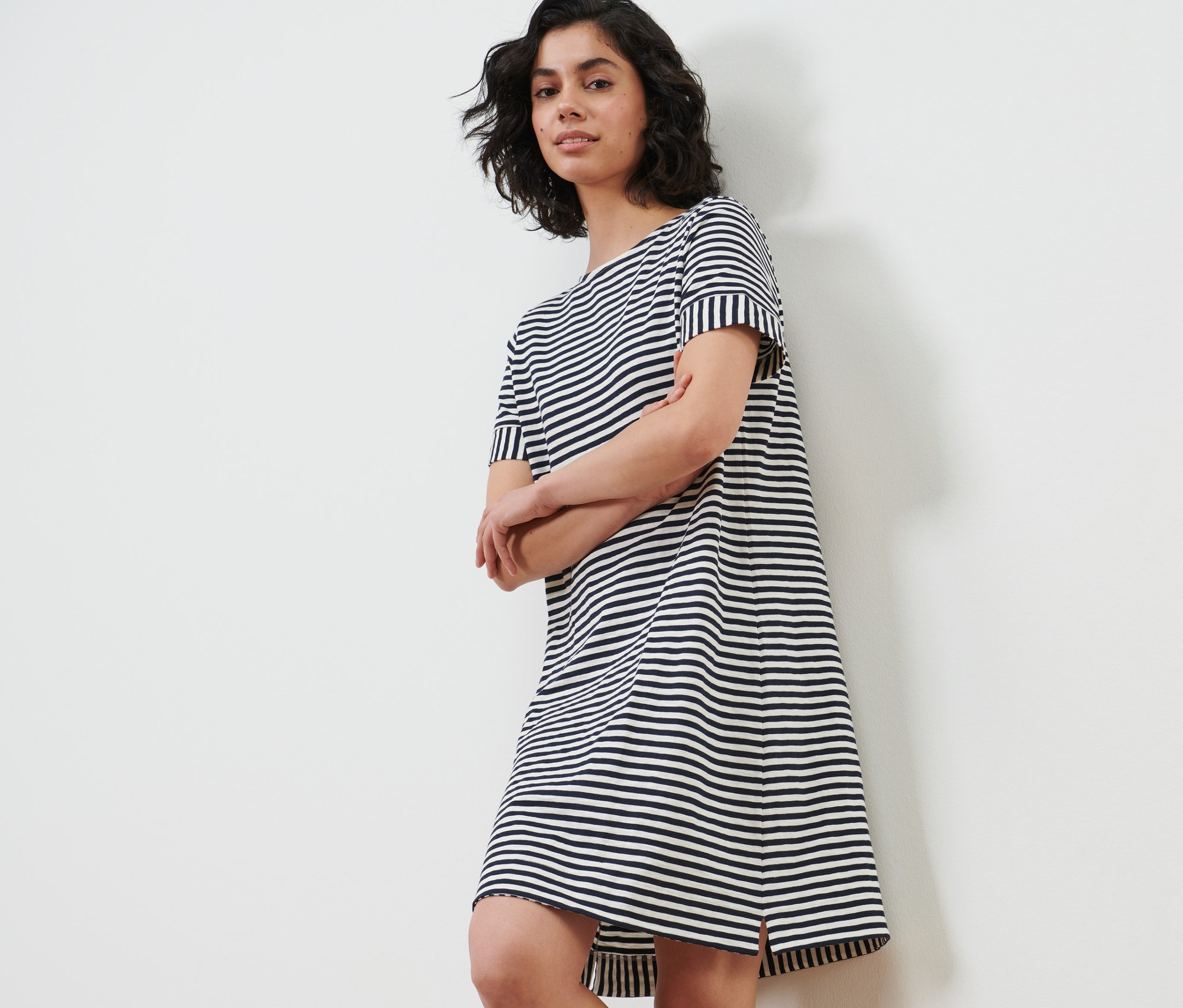 Kadın çizgili jarse elbise içinde poz veriyor.