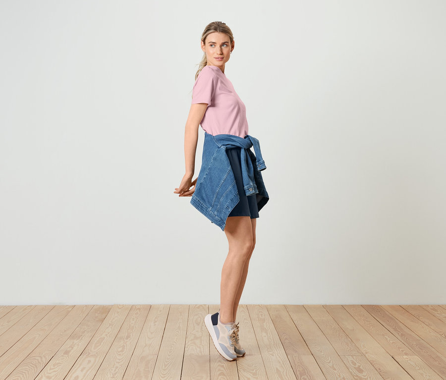 Kadın, pembe Basic T-Shirt, Kot Ceket ve Bermuda-Sweatshorts ile poz veriyor.