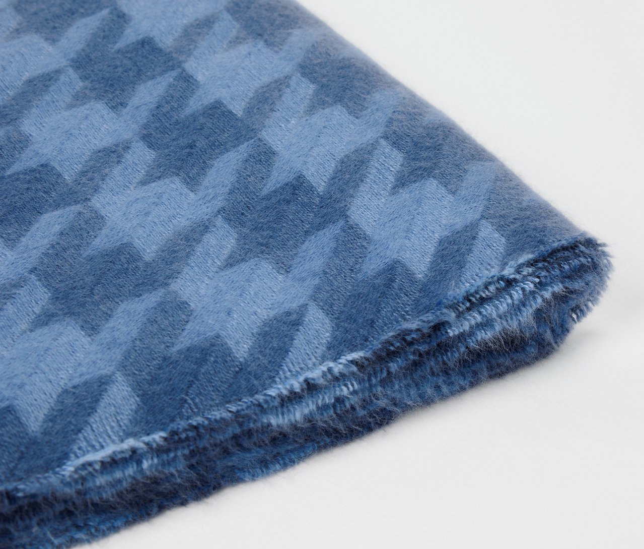 Kazayağı deseni olan mavi kumaşın yakın çekimi.