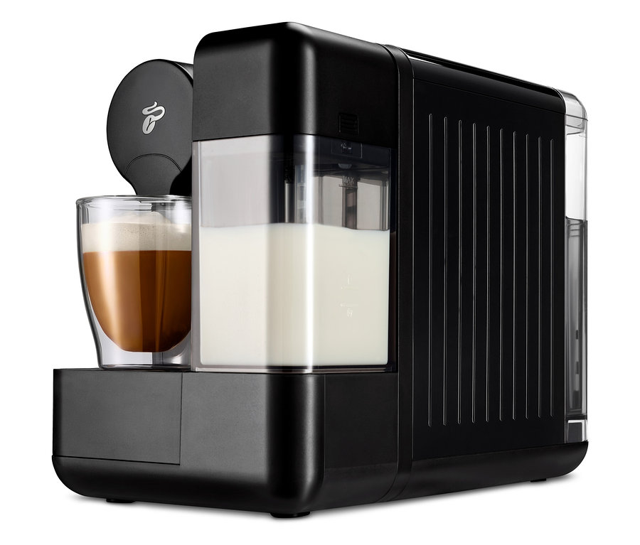 Şeffaf bir bardakta süt bulunan siyah bir Cafissimo milk kahve makinesi.