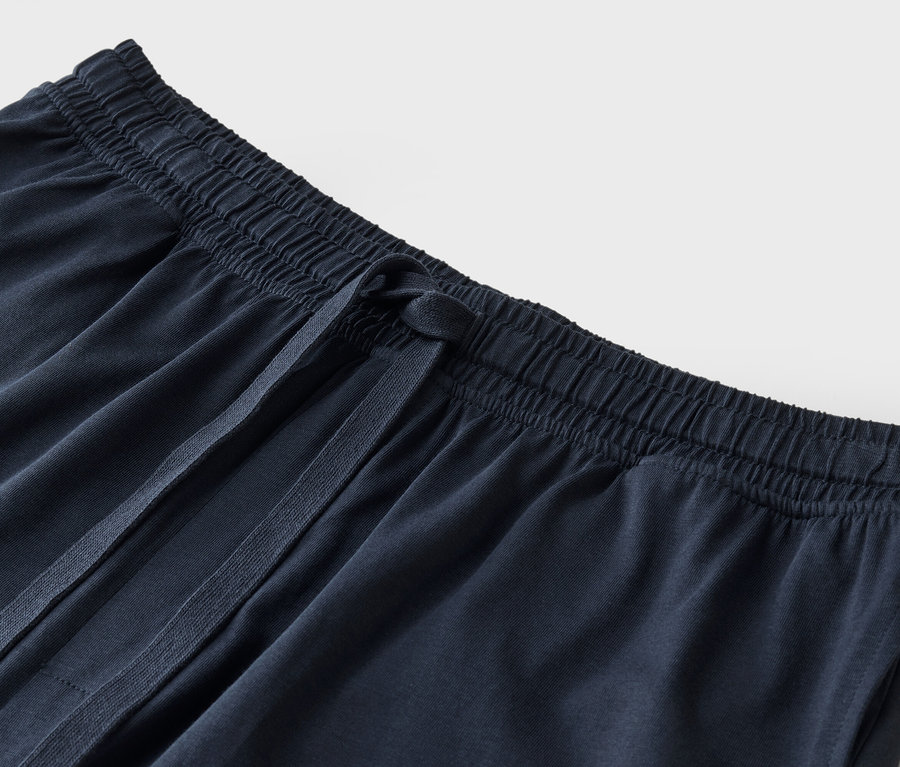 İpli, lacivert eşofman altının yakın çekimi.