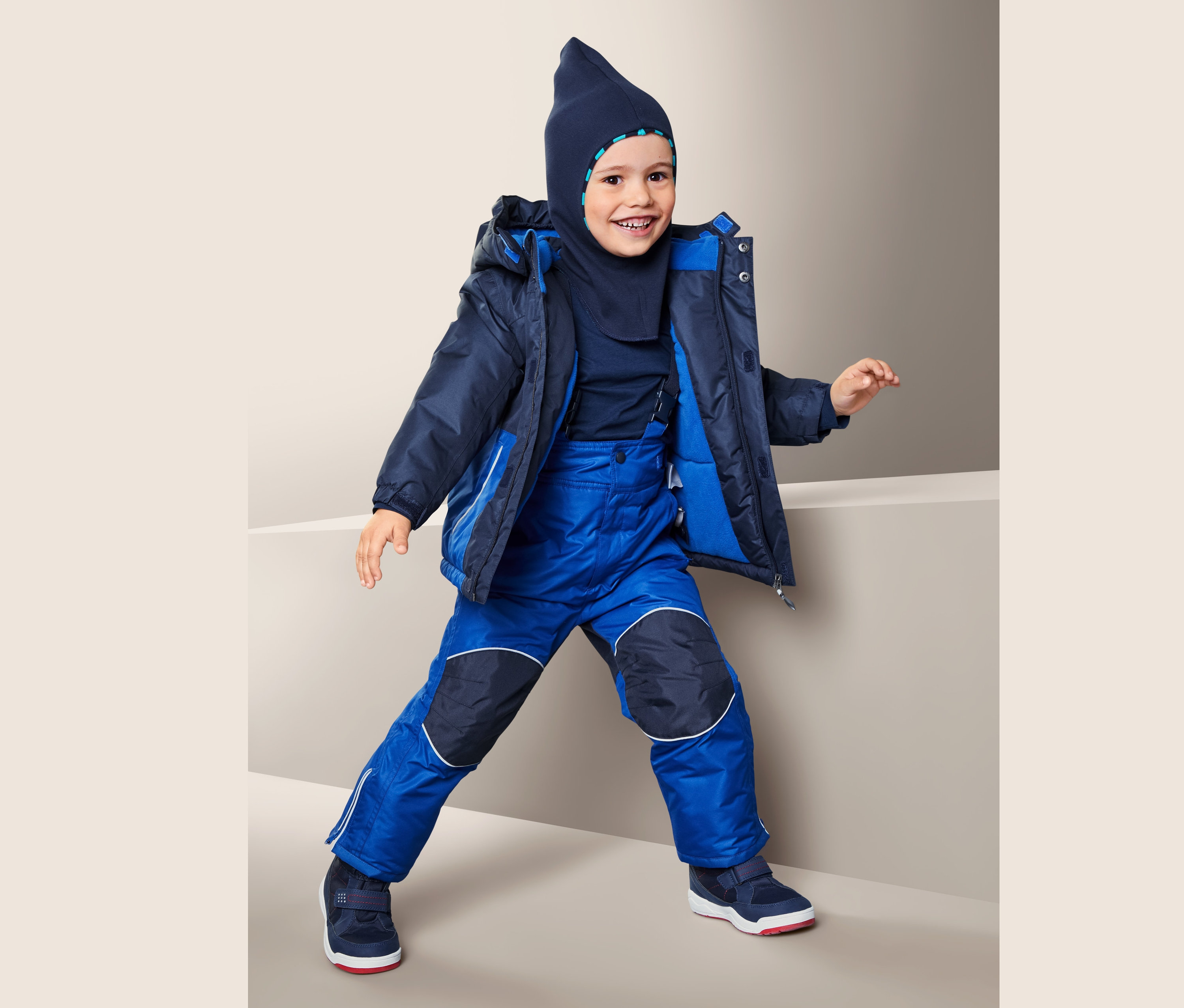 Oğlan mavi kar takımı giyiyor.