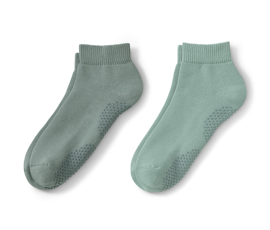 İki çift yeşil yoga çorabı yan yana duruyor.