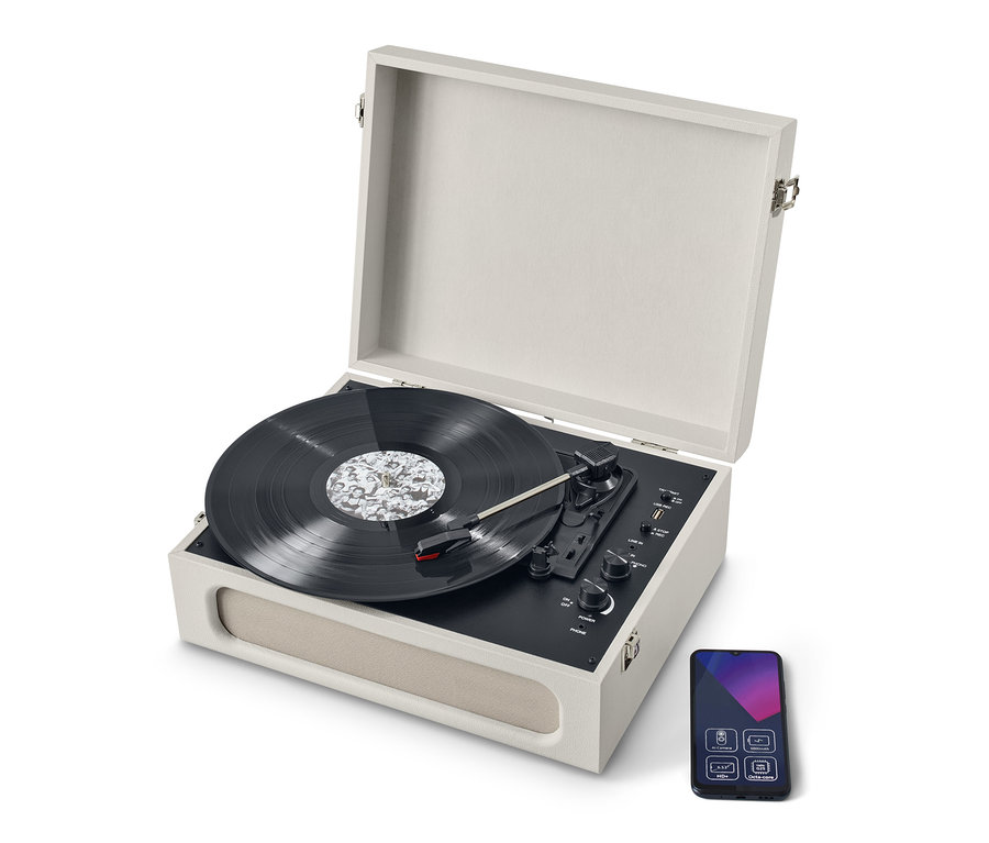 Kapağı açık ve plak olan bej rengi, Bluetooth® özellikli, taşınabilir retro pikap. Pikabın yanında bir akıllı telefon var.