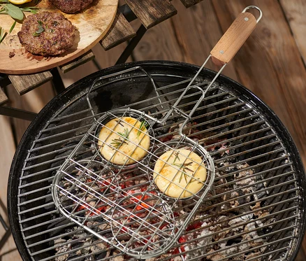 İki burger, mangal üzerinde BBQ Burger Izgara Teli içinde pişiriliyor, diğer burgerler ahşap bir tahtada duruyor.