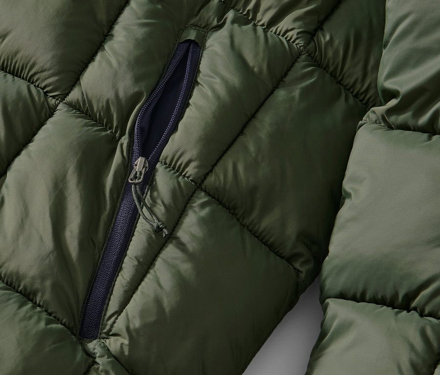 Haki kapitone montun kısmen açılmış fermuar detayı.