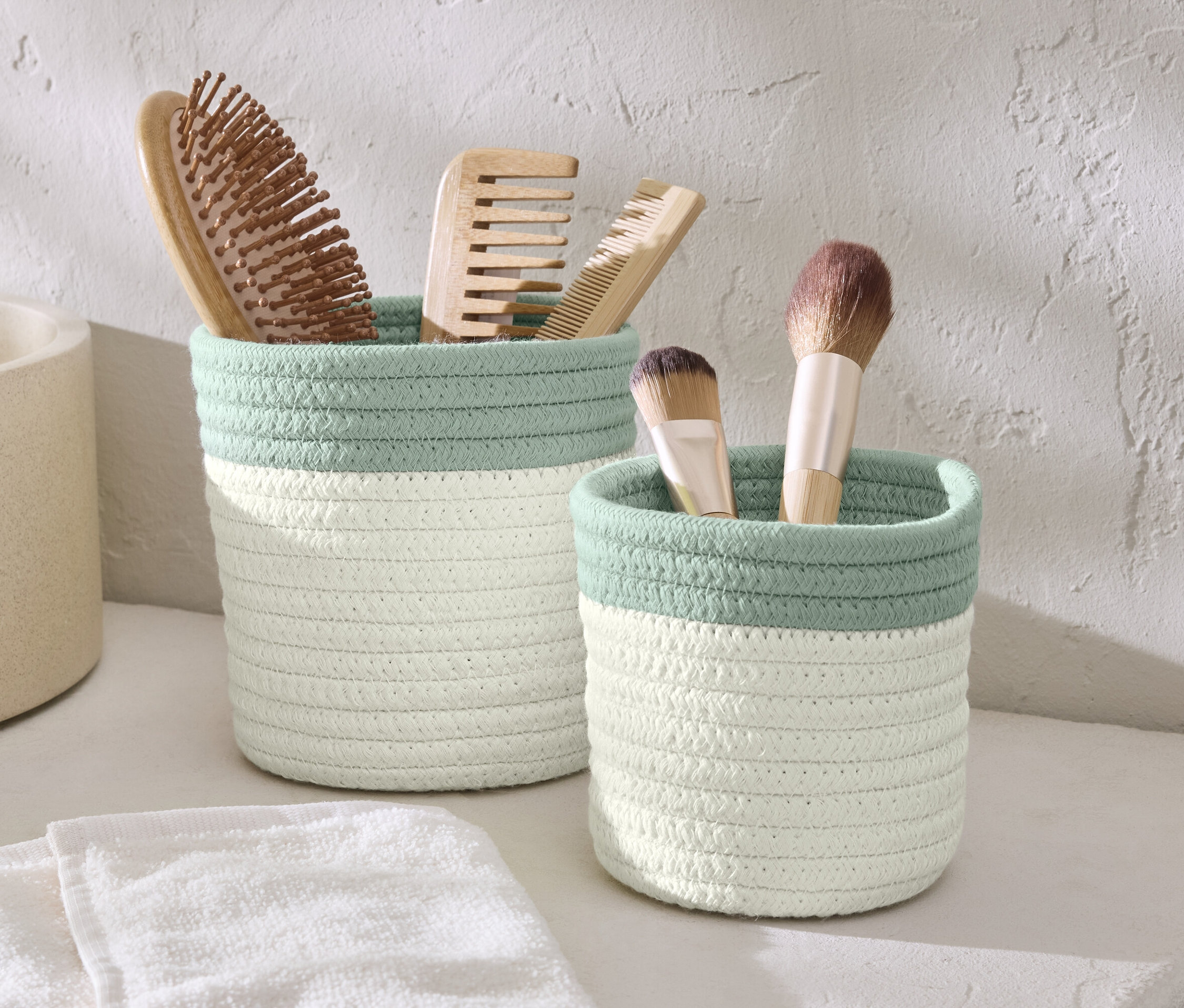 Fırça ve makyaj fırçaları olan iki saklama sepeti.