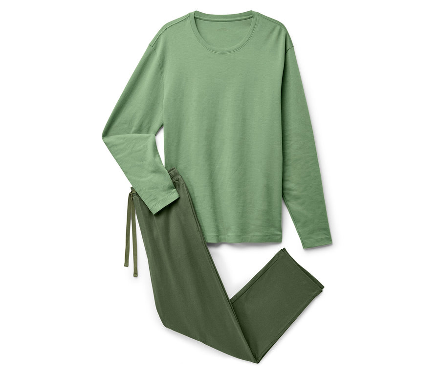 Uzun kollu ve pantolonlu yeşil bir pijama beyaz bir zemin üzerinde duruyor.