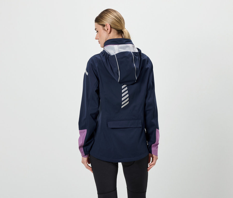 Arkadan kapüşonlu lacivert bir ceket, siyah pantolon ve mor kollu bir kadın görülüyor.