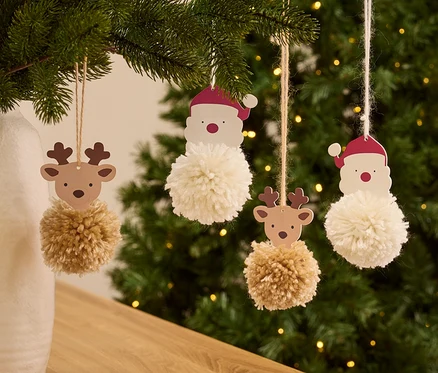 Noel ağacında ponponlu Noel Baba ve ren geyiği süsleri asılı duruyor.