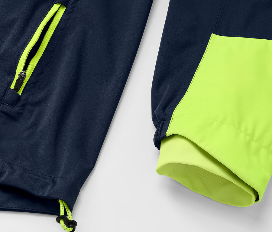 Rad-Regenjacke'nin yakından çekilmiş görüntüsü, lacivert ceket, neon sarısı fermuar ve manşet detaylarına sahip.