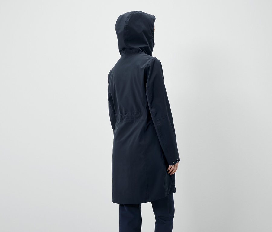 Koyu lacivert kapüşonlu bir ceket giyen bir kişinin arka görünümü.