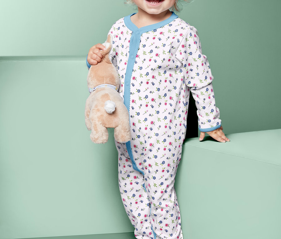 Pijamalı bir çocuk peluş bir tavşan tutuyor.