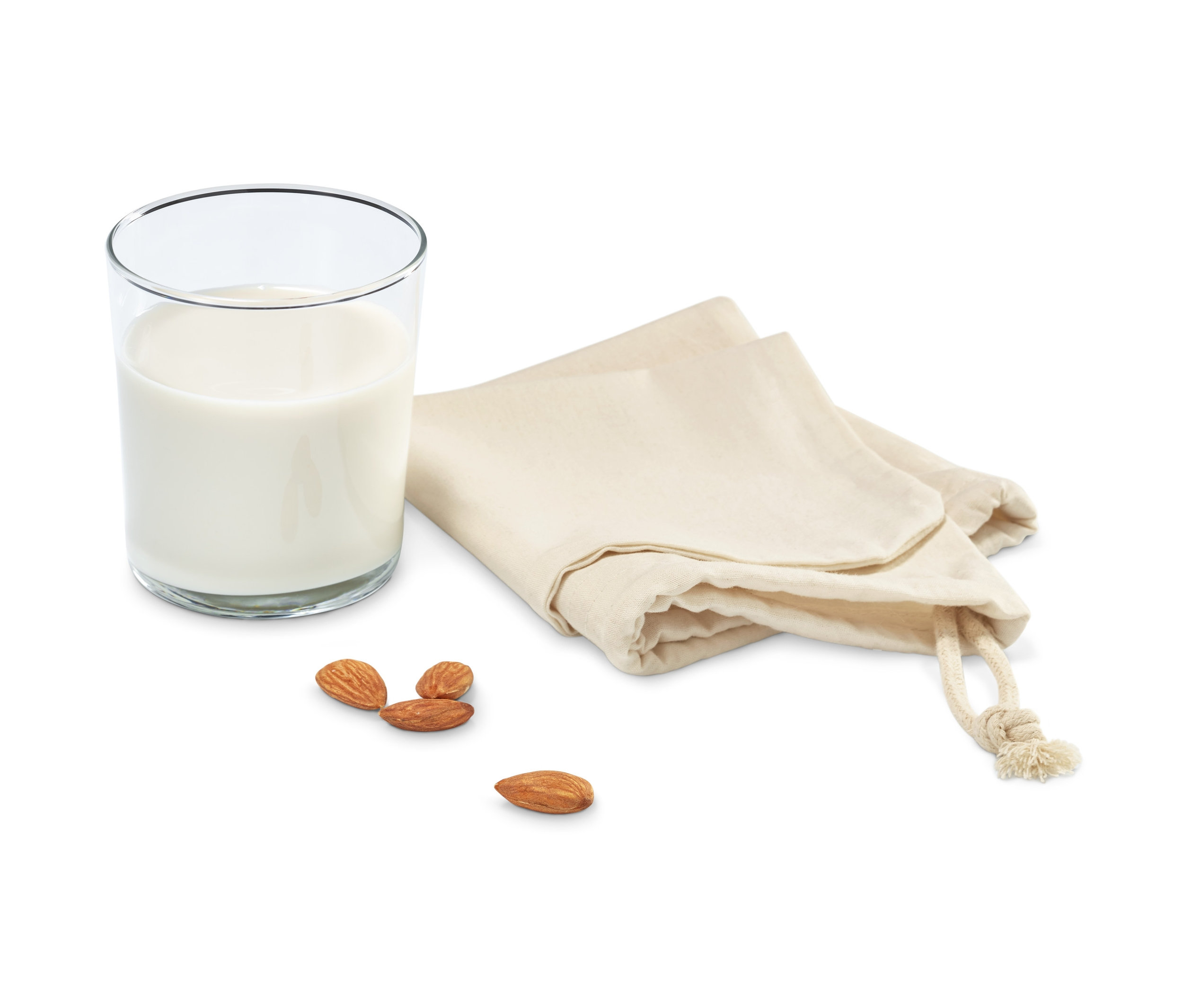 Bir bardak süt, iki bitkisel süt torbası ve birkaç bademin yanında duruyor.