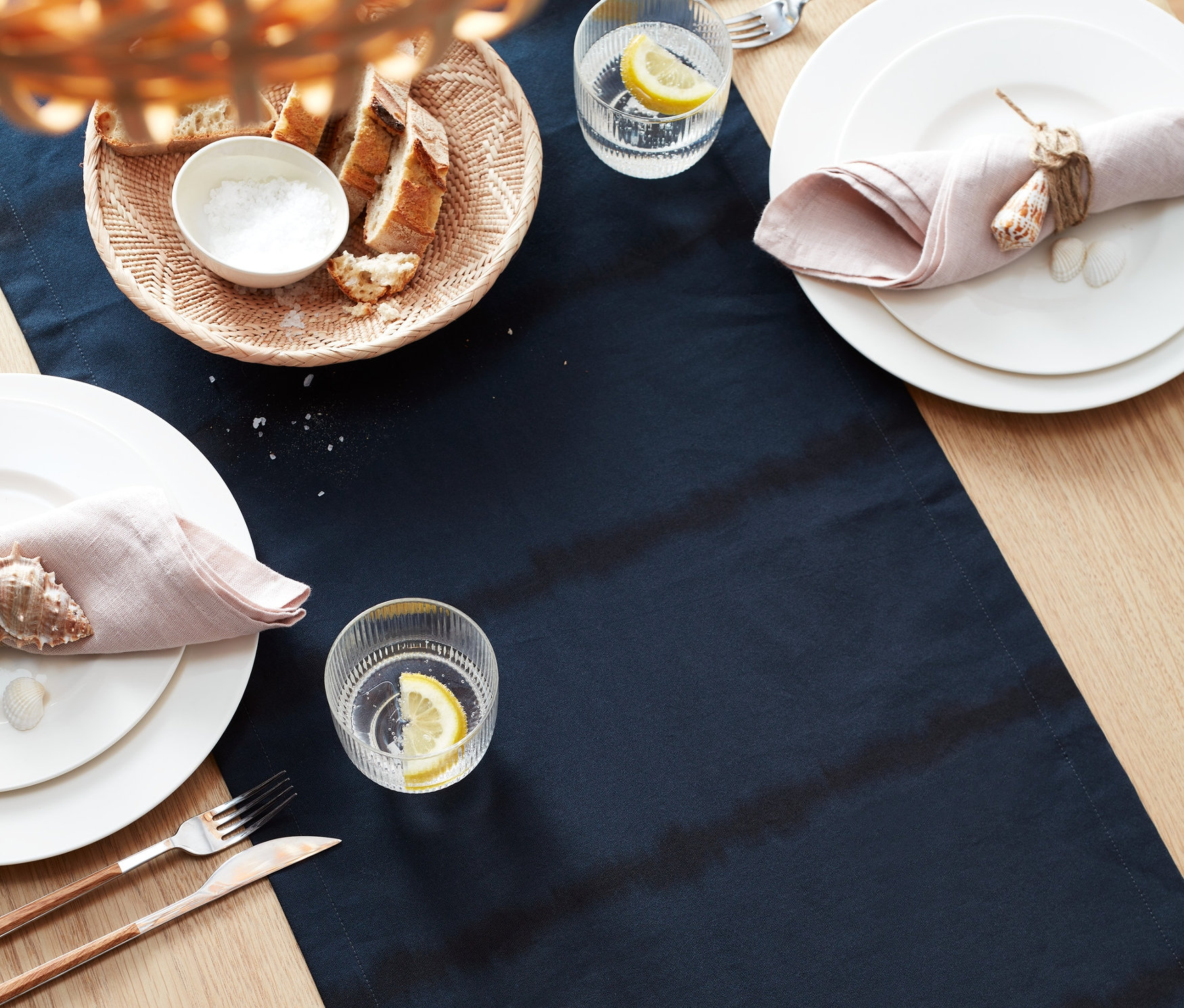 Batik Şeritli Runner, tabaklar, limonlu bardaklar ve keten peçetelerle donatılmış masa.