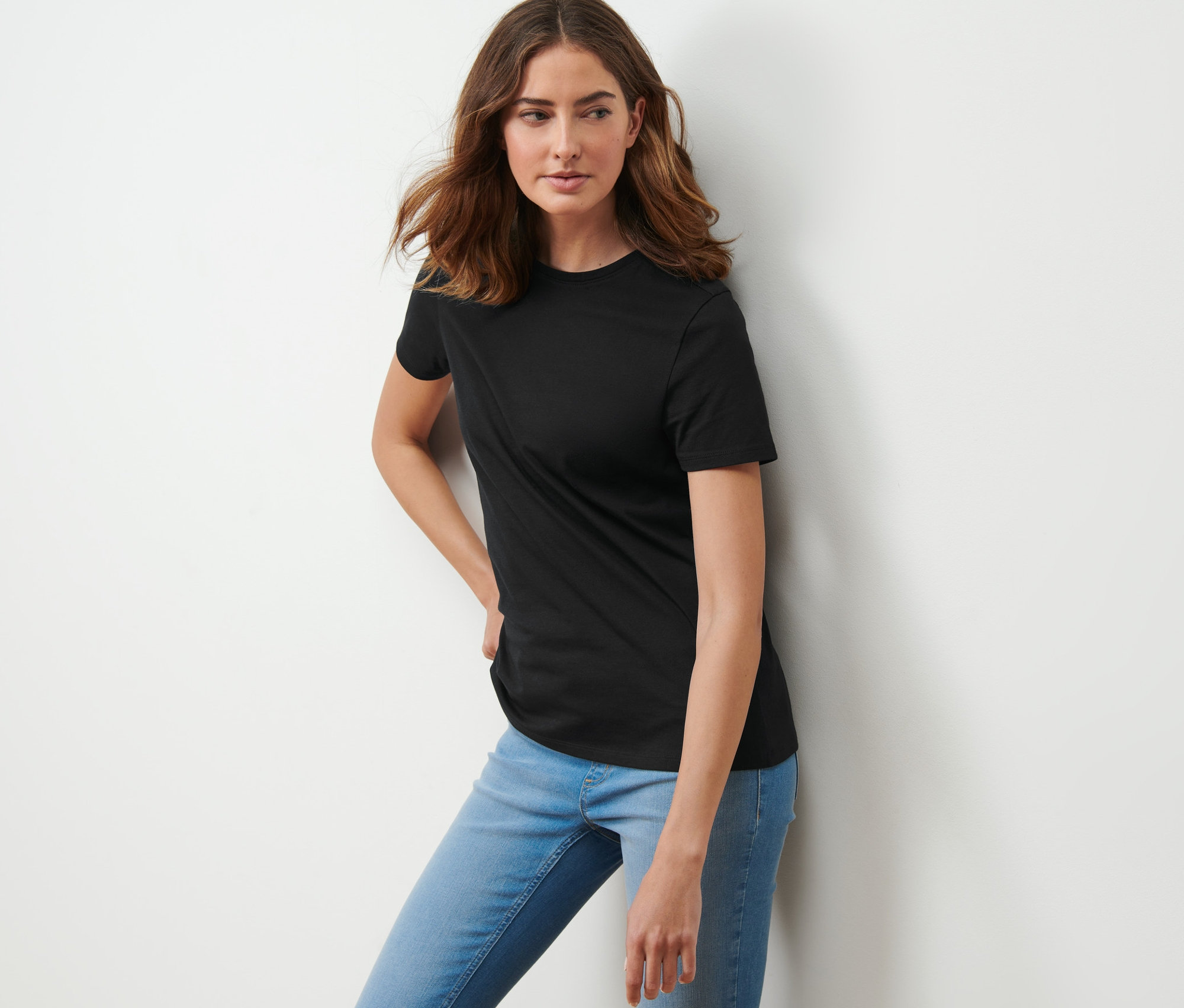 Kadın siyah tişörtle poz veriyor.