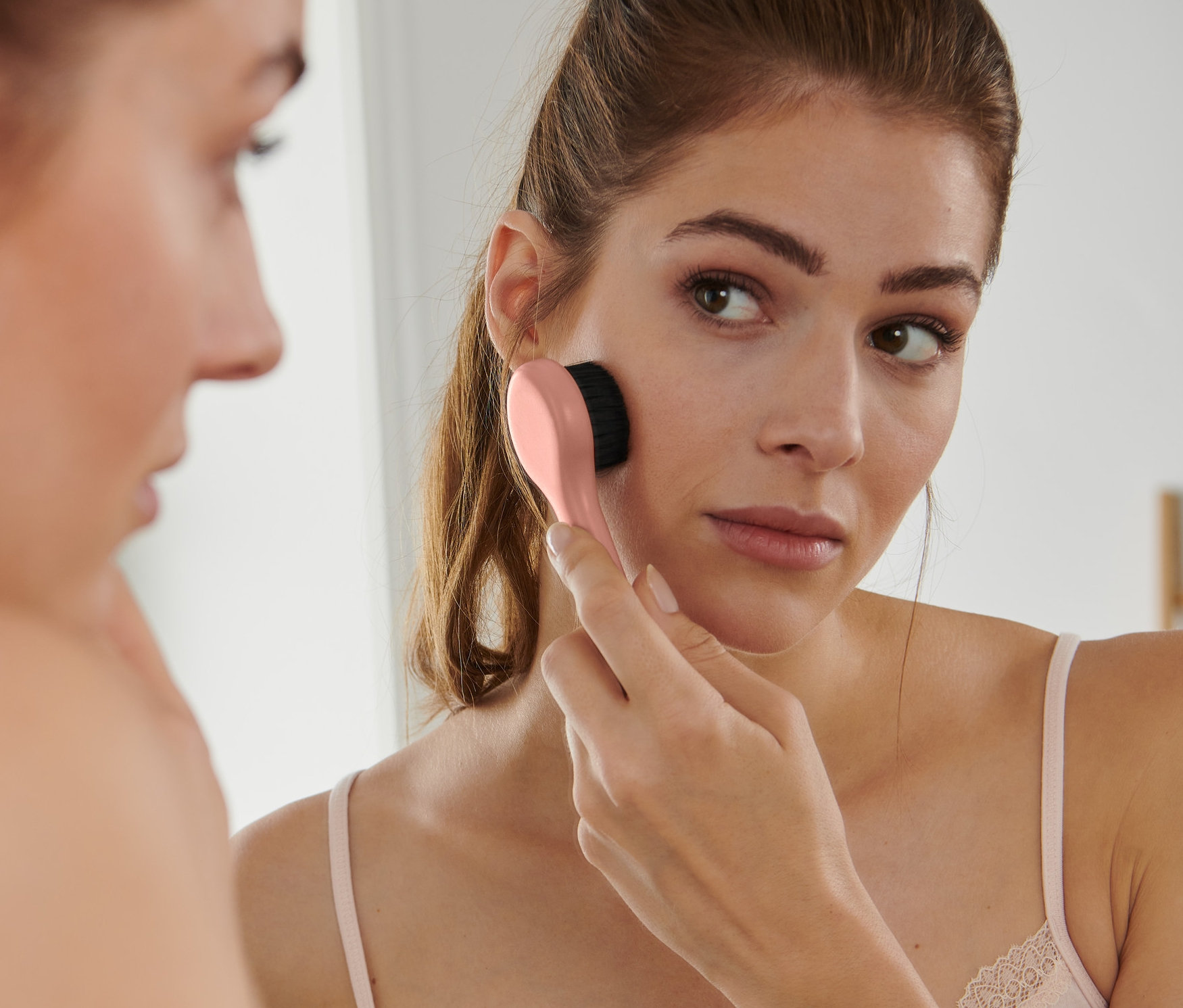 Kadın, Bakır Yüz Masaj Fırçası ile yüzüne masaj yapıyor.